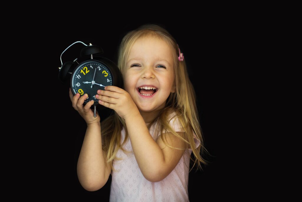 smiling child with a clock