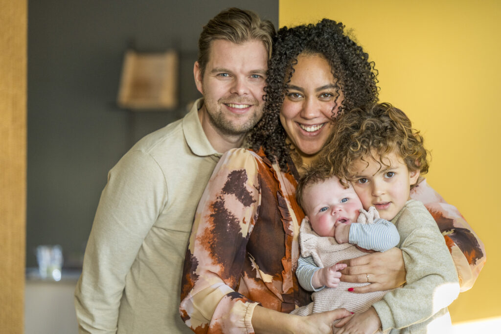 Happy family embracing at home with a warm smile.