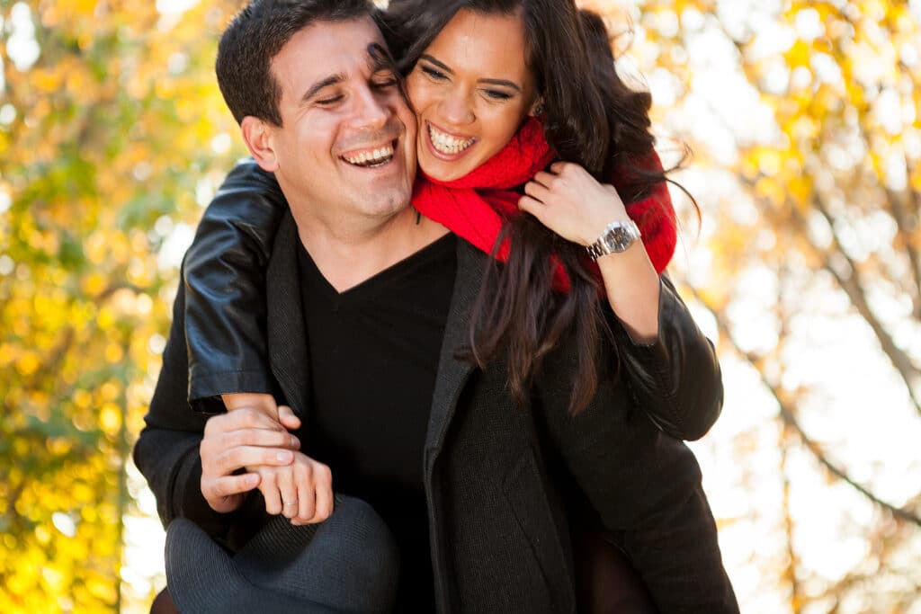 young couple in autumn park having fun