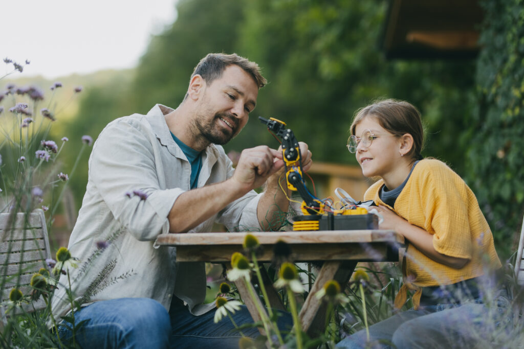 father and daughter playing with a robot