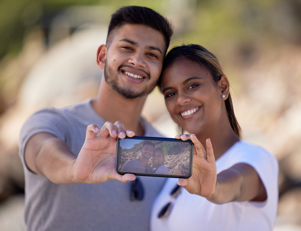 Happy couple taking phone selfie