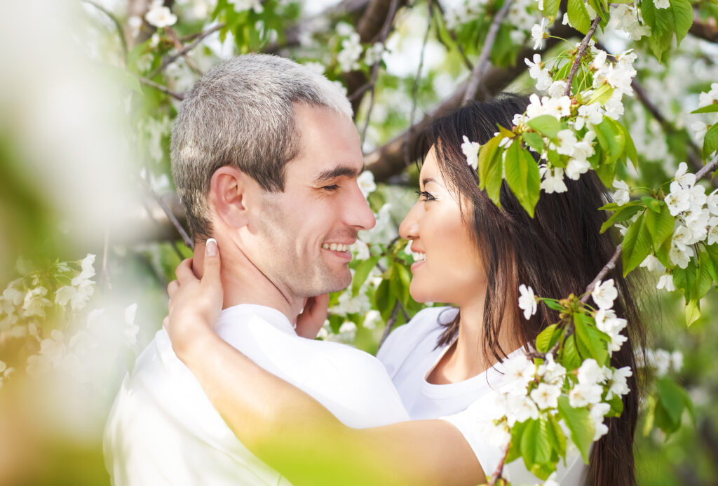 Happy smiling couple in love in bloomy spring garden