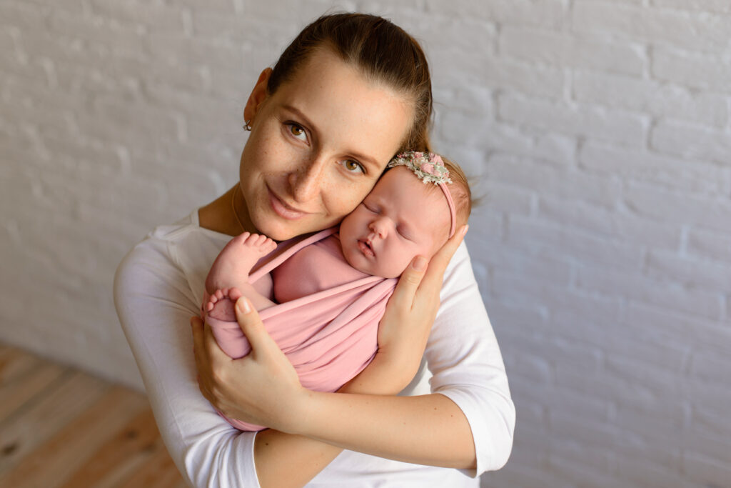 happy mum holding sleeping infant