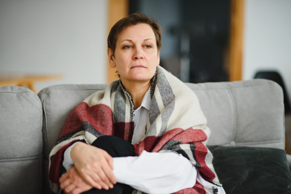 woman at home on sofa with plaid